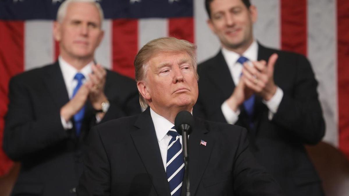 El presidente de los Estados Unidos, Donald J. Trump (C), realiza su primera alocución a una sesión conjunta del Congreso de Estados Unidos. Detrás, el vicepresidente estadounidense Mike Pence (i) y presidente de la Cámara Paul Ryan (d) el 28 de febrero de 2017.