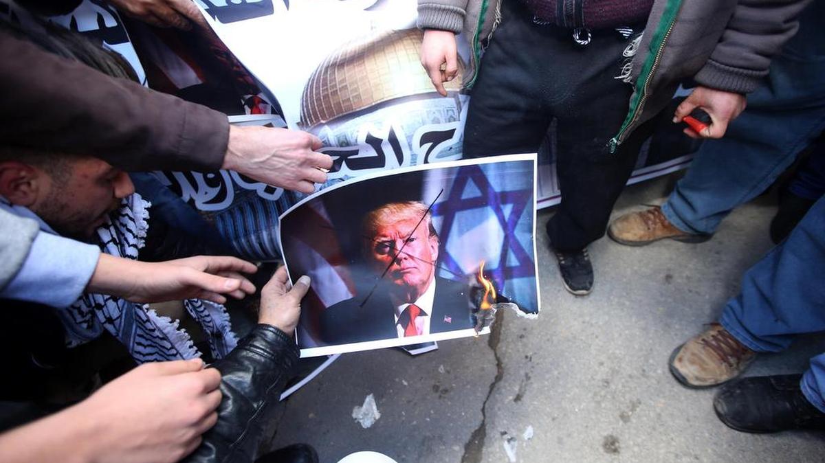 Palestinos prenden fuego a una imagen del presidente estadounidense, Donald J. Trump, durante una protesta en la ciudad cisjordana de Nablus, Palestina, el 7 de diciembre de 2017.