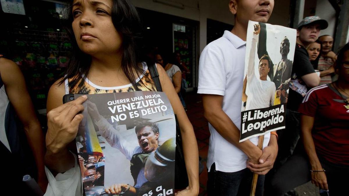 Opositores venezolanos sostienen carteles con la imagen del líder opositor Leopoldo López en las afueras del Palacio de Justicia, durante el primer día del juicio en su contra el 23 de julio del 2014.