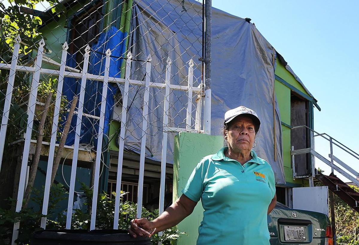 Gladys Peña frente a su casa dañada cerca de Caño Martín Peña.