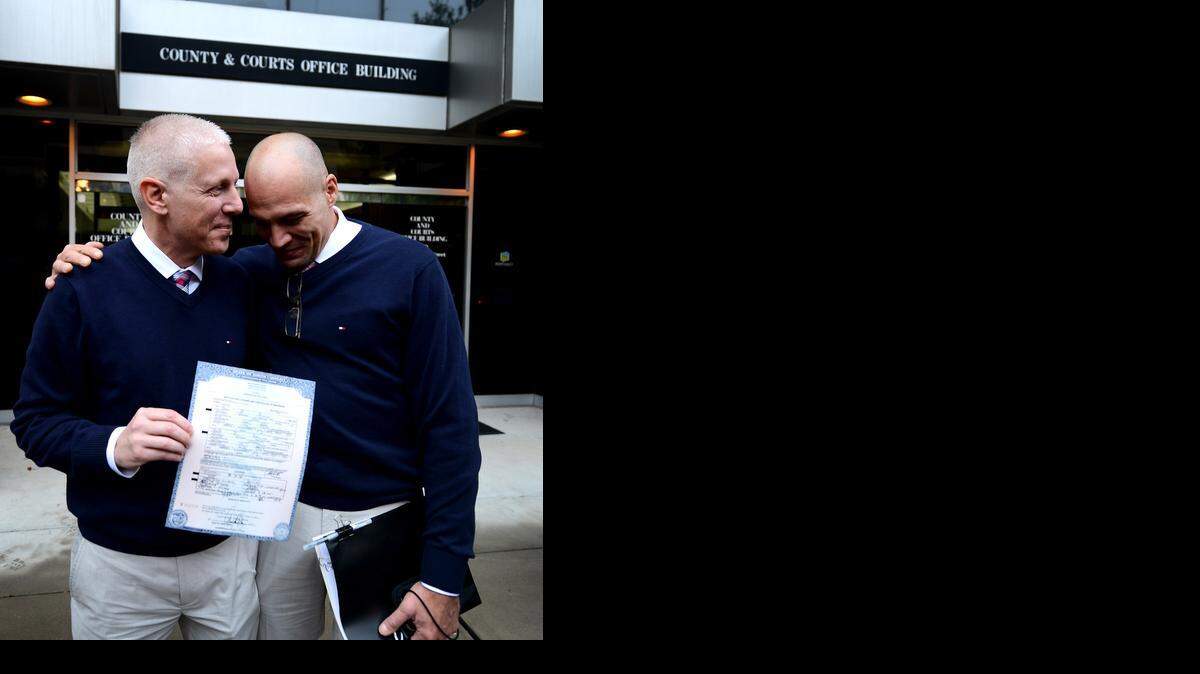 
Terrence Hall (izq.) y Christopher DeCaria de Charlotte, muestran su certificado de matrimonio en las afueras de una corte donde se realizaron ceremonias el lunes.
