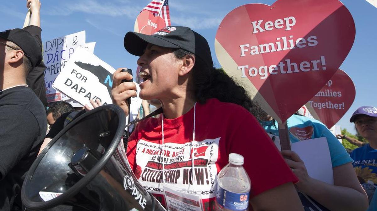 Decenas de personas sostienen carteles de apoyo a los inmigrantes afectados por los programas de Acción Diferida para Responsabilidad de los Padres (DAPA) y de Acción Diferida (DACA) durante una manifestación el lunes frente a la Corte Suprema en Washington.