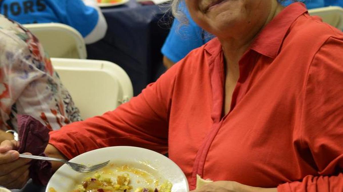Una anciana come con la ayuda de la coalición Colorado Sin Hambre (HFC).