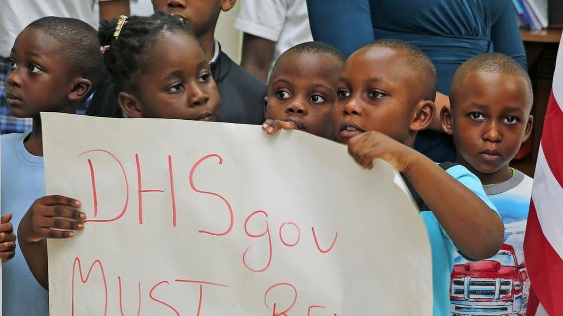 Un grupo de niños sostiene una pancarta exigiendo la renovación del Estatus de Protección Temporal (TPS), durante una conferencia de prensa de activistas el 6 de noviembre en el Pequeño Haití.