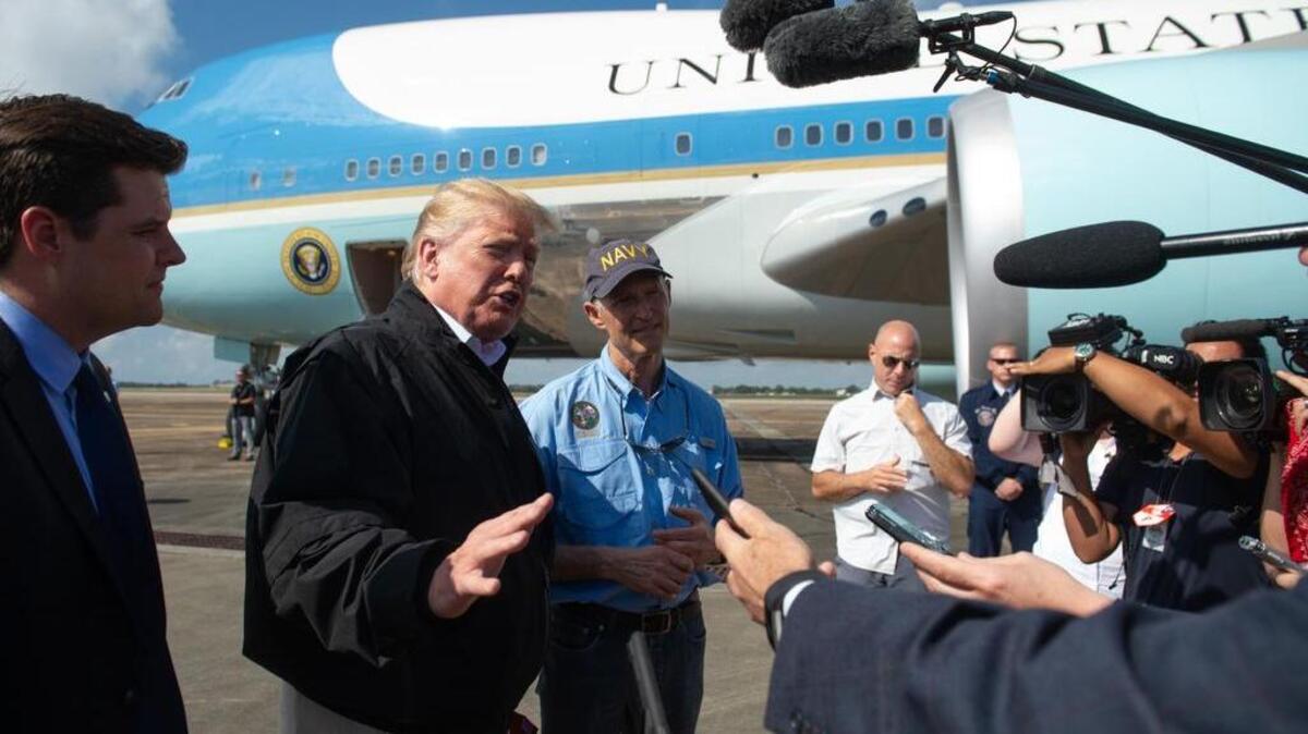 El presidente de los Estados Unidos, Donald Trump, y el gobernador de la Florida, Rick Scott, hablan a los medios de comunicación junto a Air Force One cuando Trump llega a la base aérea de Eglin en Florida, el 15 de octubre de 2018.