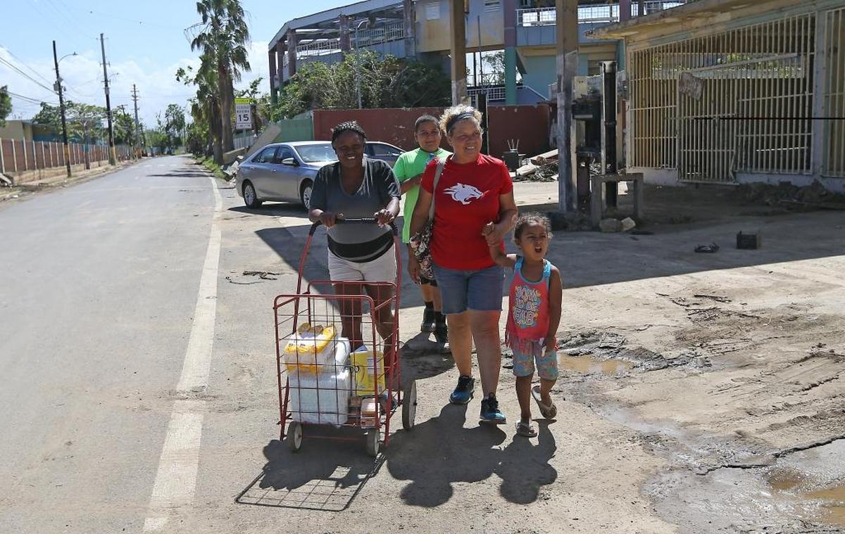 Lourdes Ayala y Carmen Santiago con sus nietos Yomar Santiago y Johalyz de la Cruz, en camino a entregar ayuda para gente necesitada tras el paso del huracán Irma por Toa Baja, Puerto Rico.
