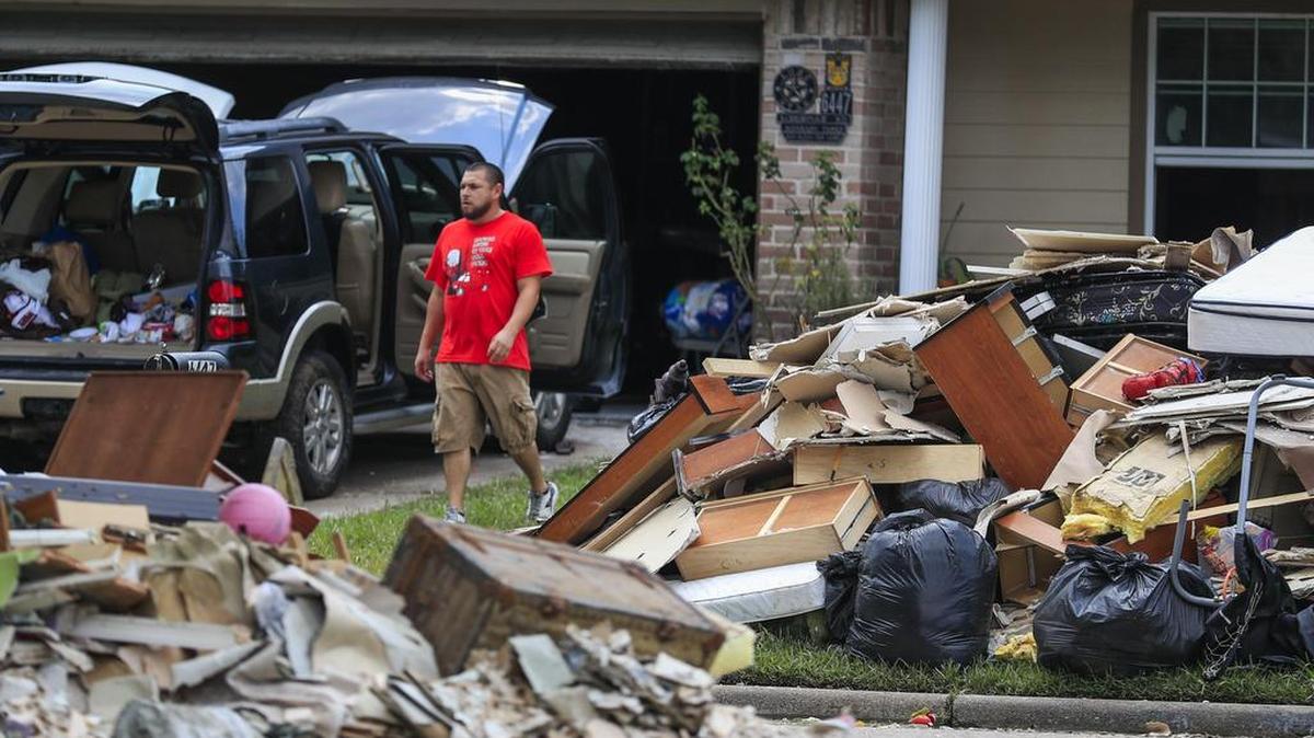 Un hombre recoge escombros de los hogares que fueron inundados por las lluvias del huracán Harvey en la vecindad de la aldea de Hunterwoods de Houston, Texas, el 3 de septiembre de 2017.