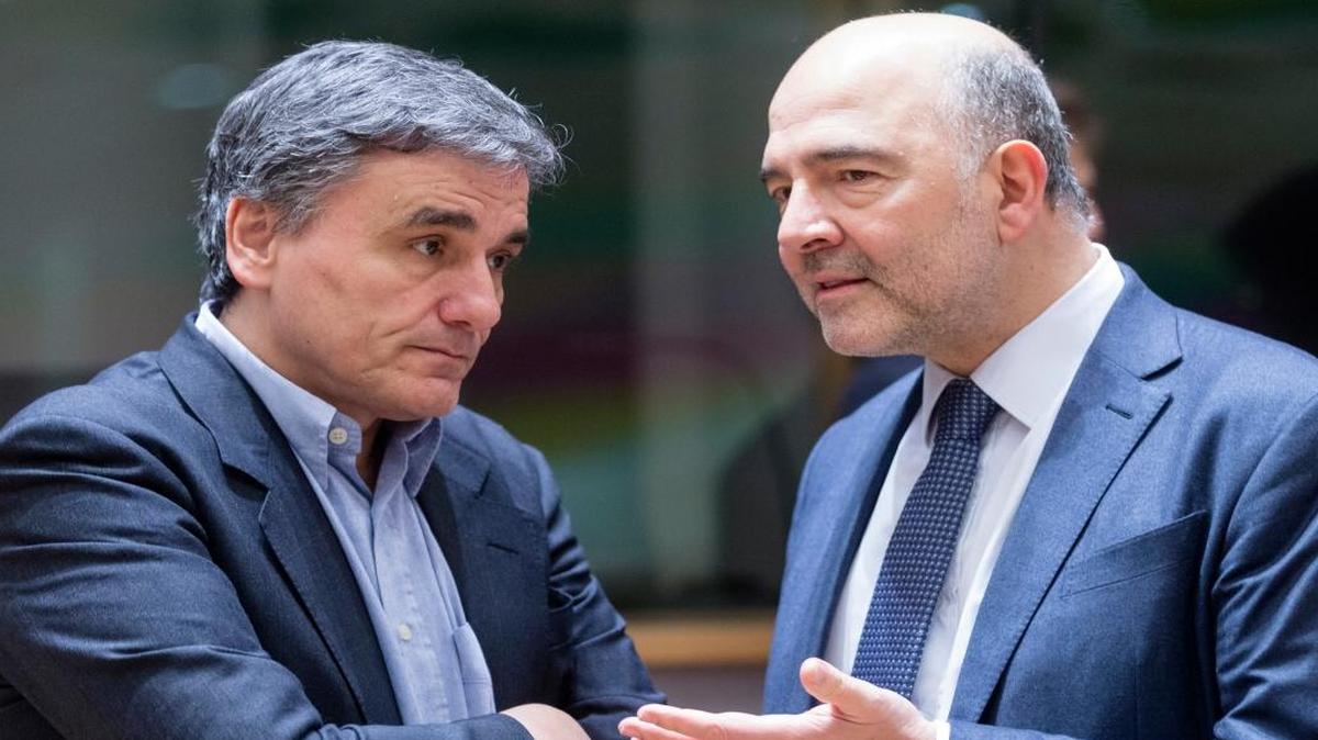El ministro griego de Finanzas, Euclides Tsakalotos (izq), conversa con el comisario de Economía y Finanzas de la UE, Fiscal y Aduanas, Pierre Moscovici, antes de una mesa redonda de ministros de Finanzas del Eurogrupo en el edificio del Consejo de la UE en Bruselas el lunes 20 de febrero de 2017. Foto de archivo.