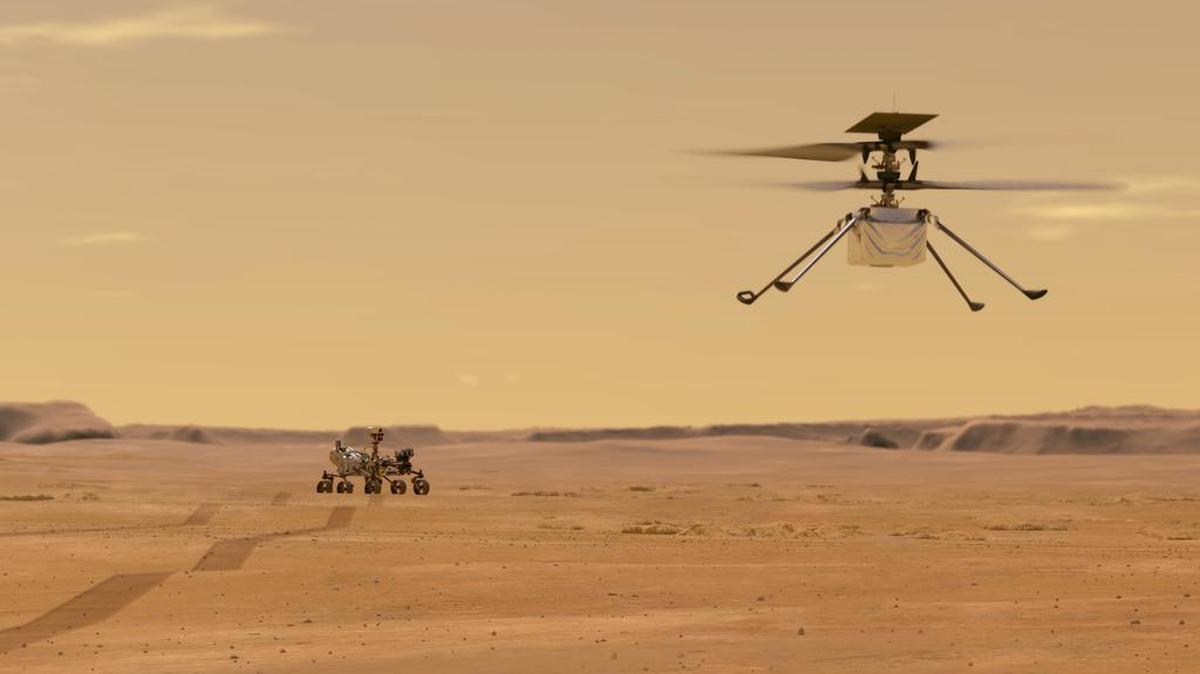 Esta ilustración facilitada por la NASA muestra el helicóptero Ingenuity en Marte, después de su lanzamiento desde el robot Perseverance, al fondo a la izquierda.