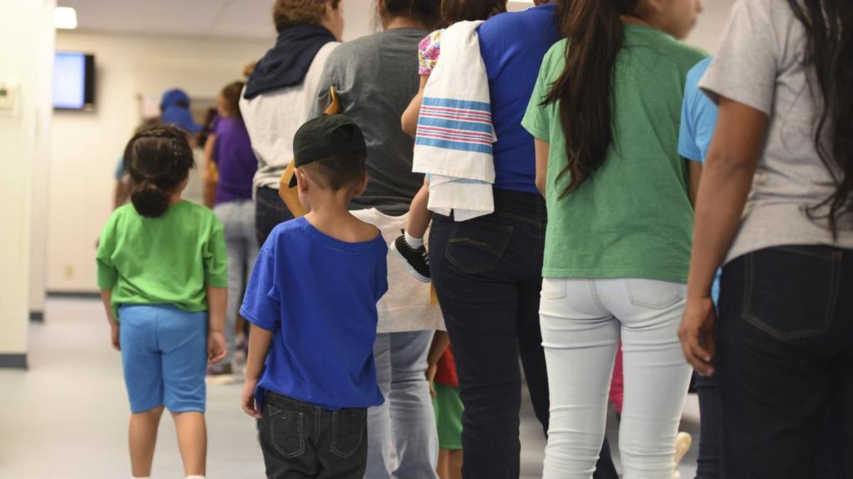 En esta foto de archivo del 9 de agosto de 2018, provista por el Servicio de Inmigración y Control de Aduanas de EEUU, Las madres y sus hijos hacen cola en el Centro Residencial Familiar South Texas en Dilley, Texas.