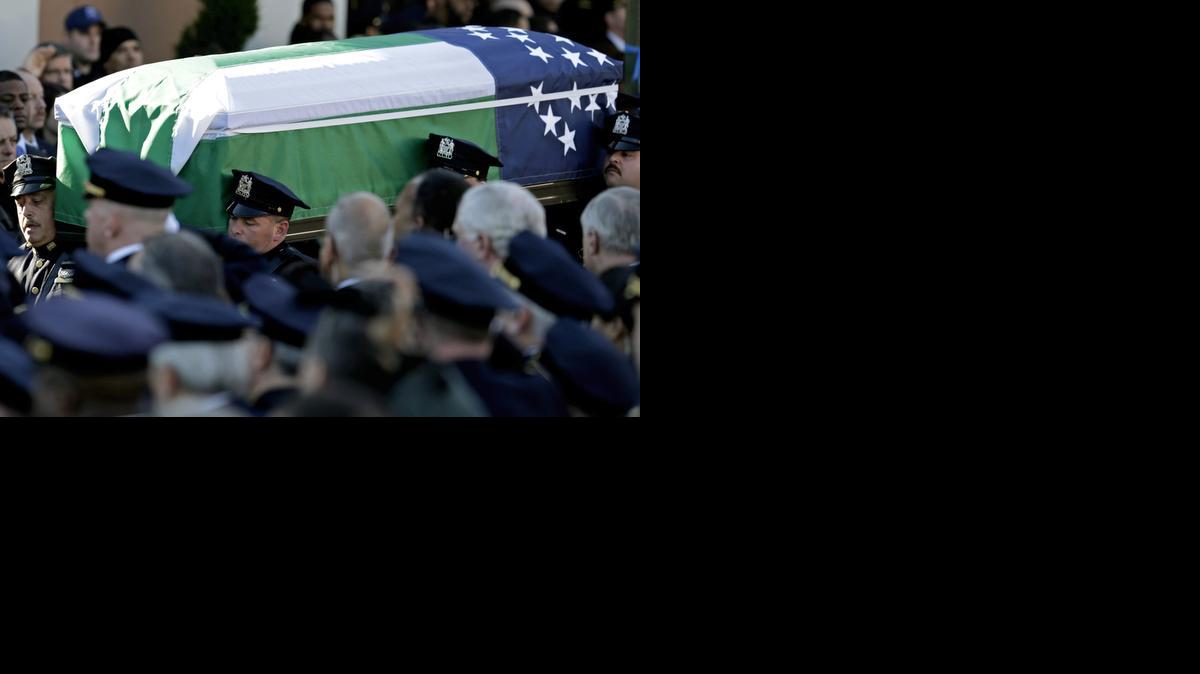 
El ataud del Oficial de Policía de Nueva York, Rafael Ramos, es llevado en hombros durante el cortejo fúnebre por compañeros del oficial asesinado hace una semana.
