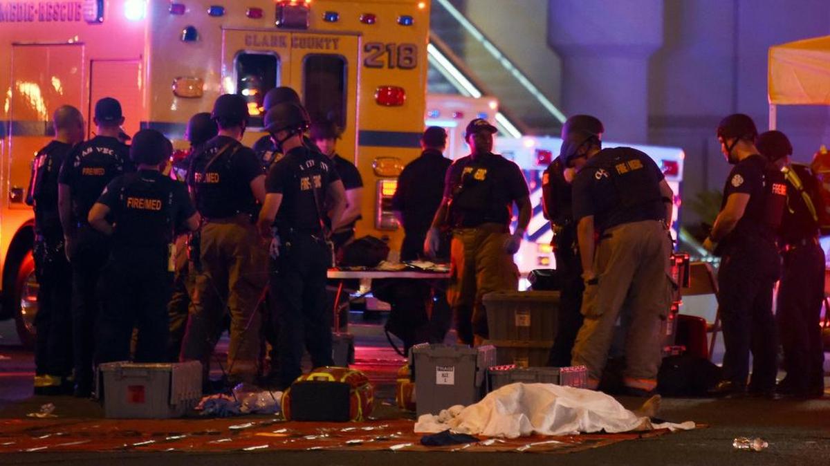 Agentes policiales y rescatistas se reúnen en una intersección de Las Vegas Boulevard, cerca del cádaver de una de las víctimas del tiroteo en masa durante un concierto en Las Vegas, Nevada.