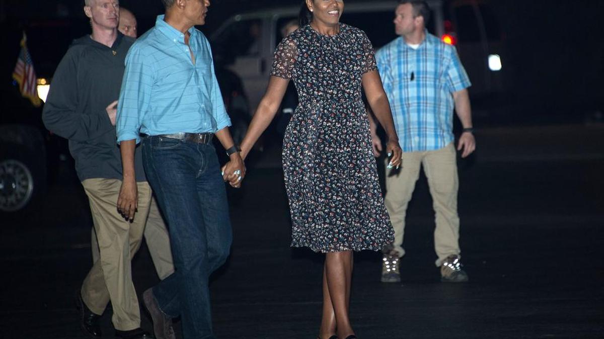 El presidente estadounidense Barack Obama y la primera dama Michelle caminan en la base conjunta Pearl Harbour-Hickam en Honolulu el 1 de enero de 2017.