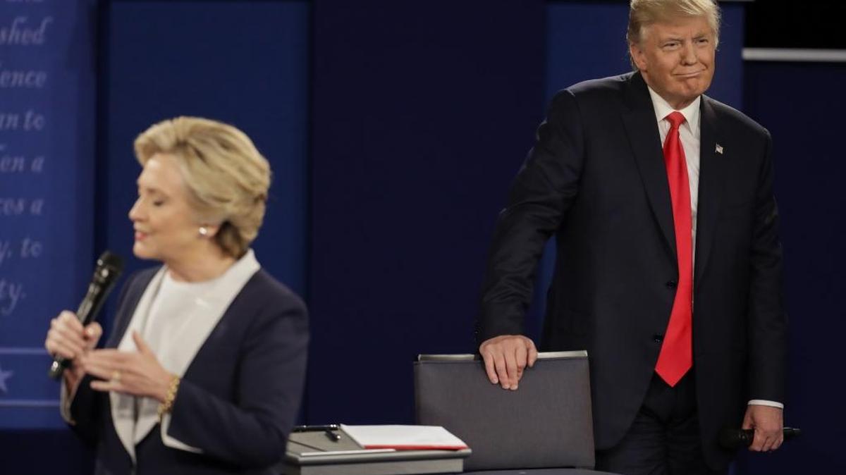 Donald Trump escucha a la derrotada candidata presidencial demócrata Hillary Clinton durante el segundo debate en St. Louis, Missouri, el 9 de octubre.