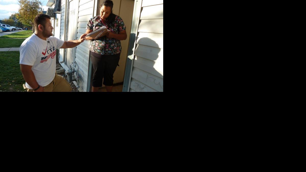 
Ricardo Martinez, voluntario de la organización no partidista Mi Familia Vota, habla con Vanesa Rojas sobre la importancia del voto latino, en Aurora, Colorado. 
