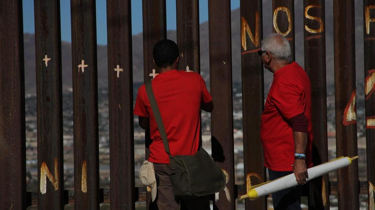 Gente mira a través del muro fronterizo entre las ciudades de Ciudad Juárez y Sunland Park durante una protesta en Ciudad Juárez, estado de Chihuahua, México el 5 de noviembre de 2017.
