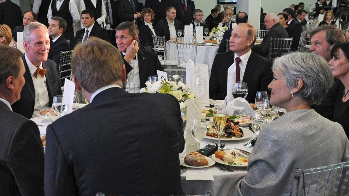 Foto facilitada el 15 de febrero de 2017 de una foto de archivo tomada el 10 de diciembre de 2015, que muestra al presidente ruso, Vladímir Putin (c-dcha), sentado junto al entonces militar retirado estadounidense Michael T. Flynn (c-izq), durante un encuentro para celebrar el 10º aniversario de la cadena de televisión RT (Russia Today) en Moscú (Rusia).