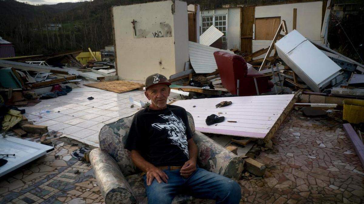 Luis Cosme poses sitting in an armchair in what is left of his house destroyed by Hurricane Maria, in Moravis, Puerto Rico, Sunday, Oct. 1, 2017. Cosme, a worker at a cleaning company, felt the high winds  and ran to the shelter at the Catholic church building. In the morning he came out and saw his house gone. “Thank God I am alive” he said. (AP Photo/Ramon Espinosa)