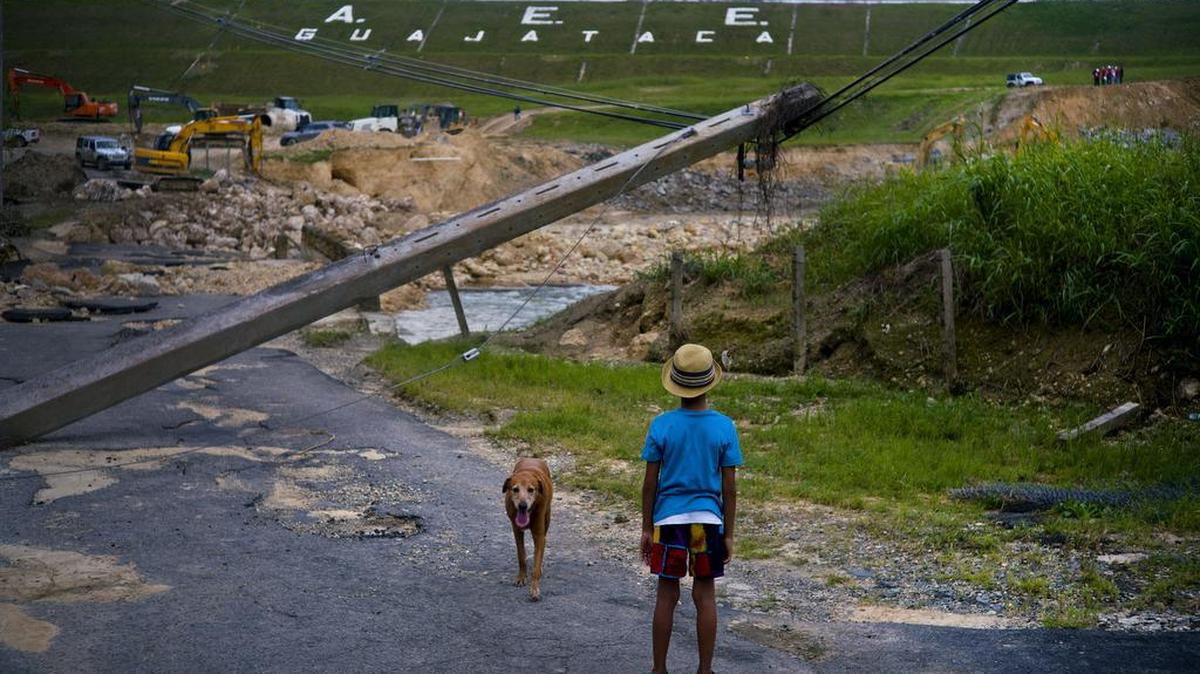 Un niño observa un poste eléctrico derribado por el huracán María en esta foto tomada el pasado 17 de octubre en Quebradillas, Puerto Rico.