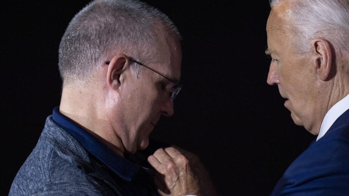 El presidente Joe Biden se quita y coloca su propio pin de la bandera estadounidense en Paul Whelan luego de su liberación como parte de un intercambio de prisioneros de 24 personas entre Rusia y Estados Unidos, en la Base Conjunta Andrews, Maryland, el jueves 1 de agosto de 2024.