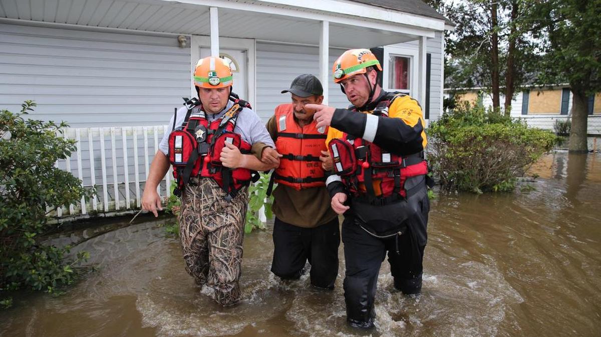 Los miembros de Lumberton North Carolina Fire and Rescue ayudan a un residente a atravesar aguas inundadas en Lumberton, Carolina del Norte el 17 de septiembre de 2018.