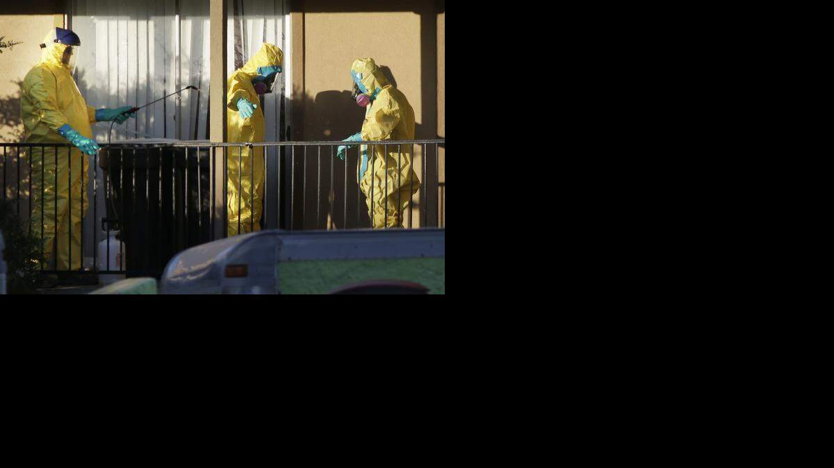 
El equipo que trabajó en el apartamento de Thomas Eric Duncan es desinfectado antes de quitarse los trajes de protección contra el virus del ébola.


