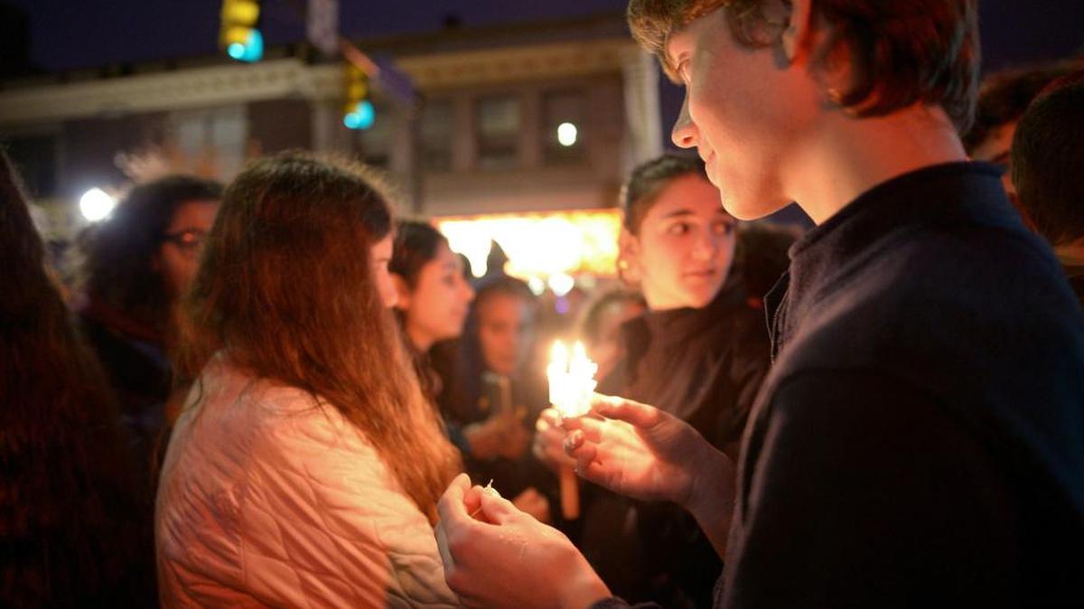 Un joven sostiene una vela mientras los miembros de la comunidad de Squirrel Hill se congregan en una vigilia para honrar a las víctimas del ataque en una sinagoga de Pittsburgh, el 27 de octubre de 2018.
