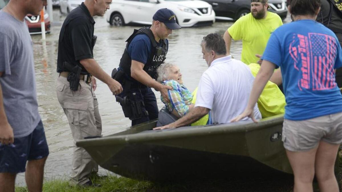 Varios agentes guardacostas rescatan a los internos de una residencia de ancianos durante las labores de salvamento en Baton Rouge, Louisiana.