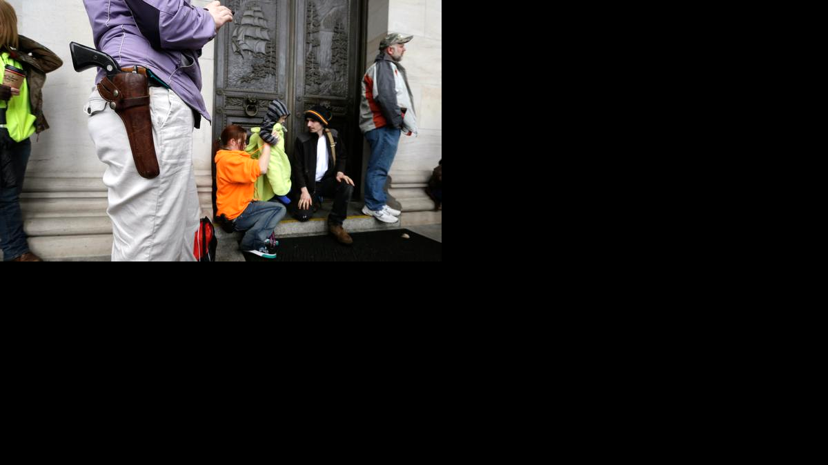 Foto de archivo. Una mujer, que lleva un revolver en una cartuchera al cinto, protesta junto a otros manifestantes armados a favor del porte libre de armas. 