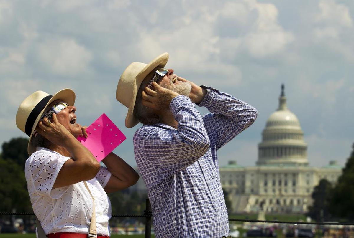 Libia Granada y James McDonough observan el eclipse solar, en el National Mall de Washington, el lunes 21 de agosto de 2017.