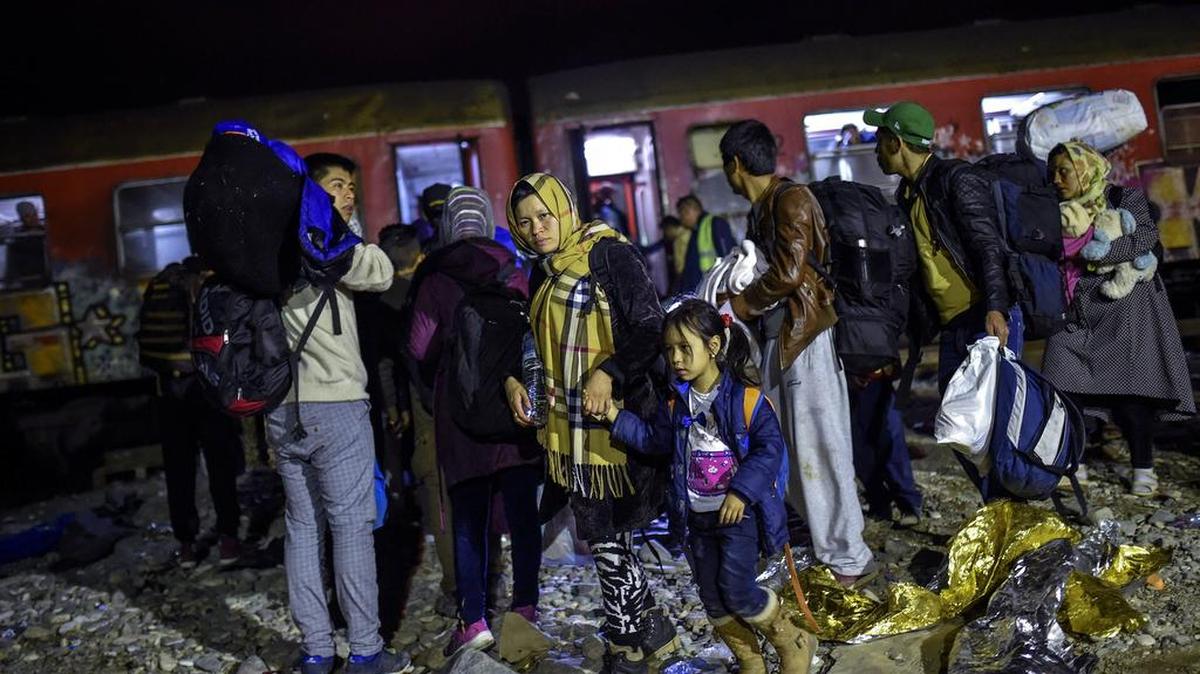Los inmigrantes hacen cola para subir al tren en dirección a la frontera con Serbia, cerca de la ciudad de Gevgelija, la ex República Yugoslava de Macedonia, 18 de octubre de 2015.