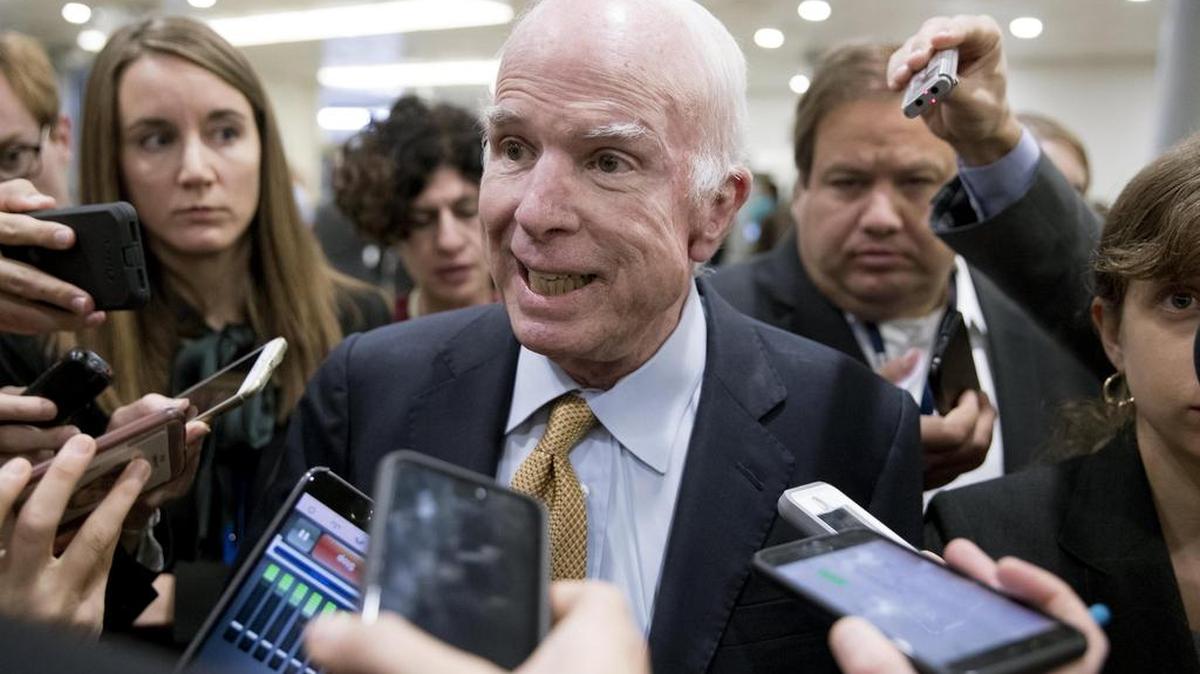 El senador republicano por Arizona John McCain (c) habla con la prensa en uno de los túneles del Senado previo a dirigirse a una votación procesal que permitirá avanzar en el debate sobre la reforma tributaria de ese país el martes 17 de octubre de 2017, en Washington