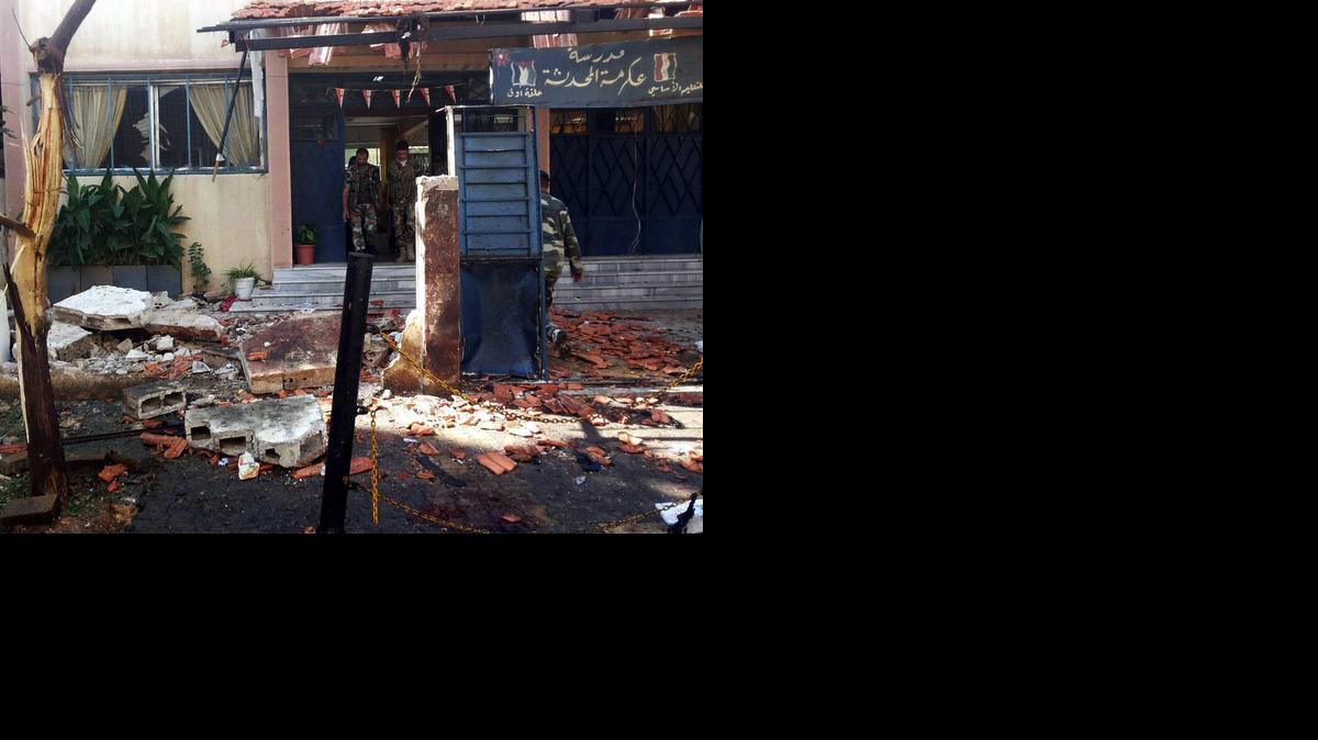 <cutline_leadin>Policias sirios</cutline_leadin> mientras inspeccionan los daños registrados en una escuela tras el atentado perpetrado en el barrio de mayoría alauita, en Homs, Siria, el miércoles.<252><252>