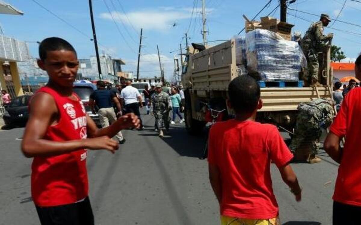 Habitantes del barrio Obrero, Santurce, reciben ayudas tras el paso del huracán María el domingo 24 de septiembre de 2017, en San Juan (P. Rico). Puerto Rico espera que la llegada de ayuda con suministros contribuya a mejorar el caos generalizado provocado por el paso por isla del huracán María, que destrozó infraestructuras y el sistema eléctrico, dejó 9 muertes, cifra todavía provisional, y 15,000 refugiados.