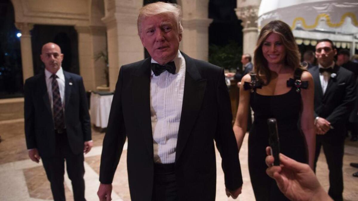 El presidente electo de Estados Unidos, Donald Trump, responde a las preguntas de los periodistas acompañados por su esposa Melania durante una fiesta de Nochevieja el 31 de diciembre de 2016 en Mar-a-Lago en Palm Beach, Florida.