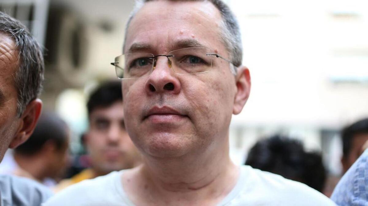 En esta foto de archivo tomada el 25 de julio de 2018, el pastor estadounidense Andrew Brunson, escoltado por las autoridades llega a su casa el 25 de julio de 2018 en Esmirna.