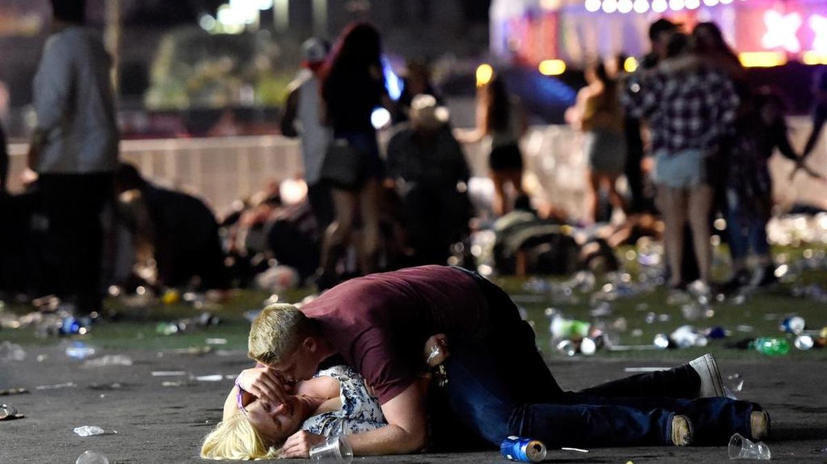Un hombre trata de ayudar a una de las heridas del tiroteo en un festival de música country después de un tiroteo el 1 de octubre de 2017 en Las Vegas, Nevada.