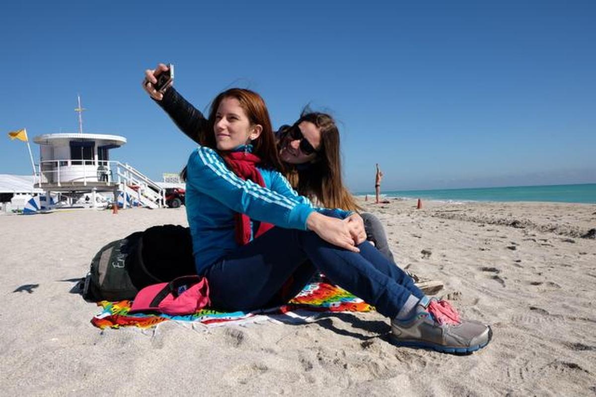 Las brasileñas Aline Silva y su hermana Cristina se toman un selfie en la desierta playa de Miami Beach esta mañana. Ambas llegaron de vacaciones desde su país y se vieron sorpredidas por la ola de frio que está afectando el sur de la Florida.