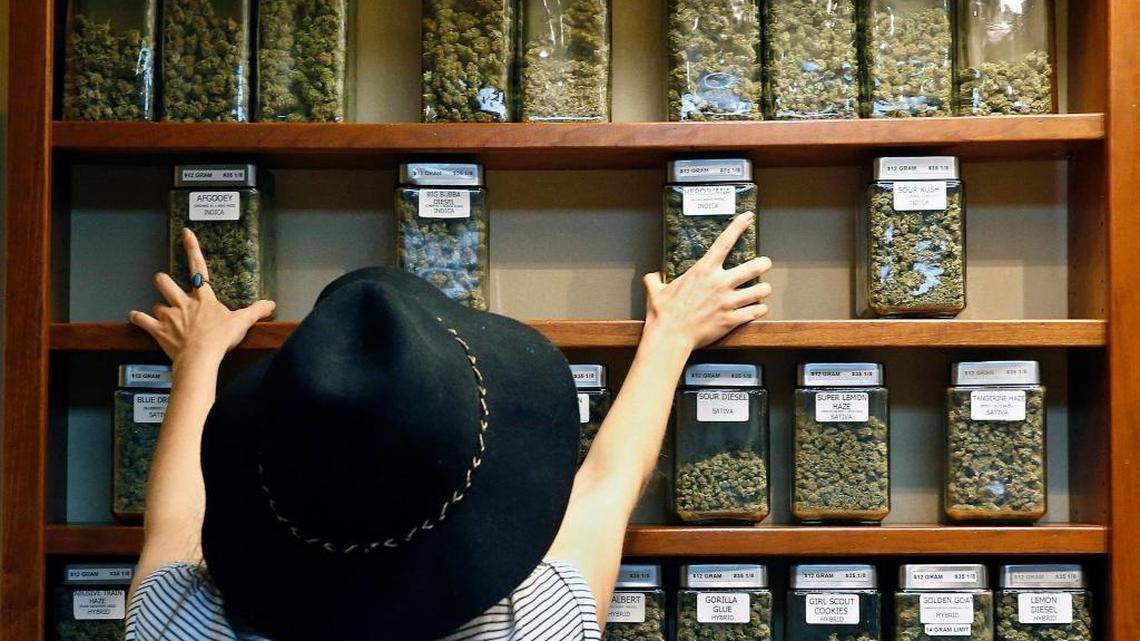 Jaclyn Stafford arregla los anaqueles del dispensario de de marihuana medicinal The Station en Boulder, Colorado, en el 2016.