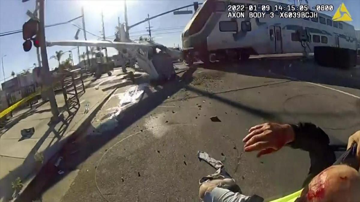 En esta captura de pantalla de un video de cámara corporal proporcionado por el Departamento de Policía de Los Ángeles, un tren de cercanías choca con un avión que acababa de despegar del cercano Aeropuerto Whiteman el domingo 9 de enero de 2021 en Pacoima, California. La imagen muestra a un piloto herido por los restos de un pequeño avión que se estrelló contra las vías del tren, momentos antes de que un tren de cercanías se estrellara contra el avión durante el fin de semana. (Foto AP/Departamento de Policía de Los Ángeles vía AP)