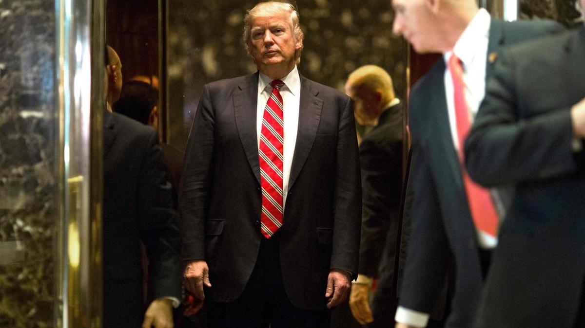 El presidente electo de Estados Unidos, Donald Trump, aborda el ascensor después de escoltar a Martin Luther King III al vestíbulo después de las reuniones en la Torre Trump en Nueva York el 16 de enero de 2017.