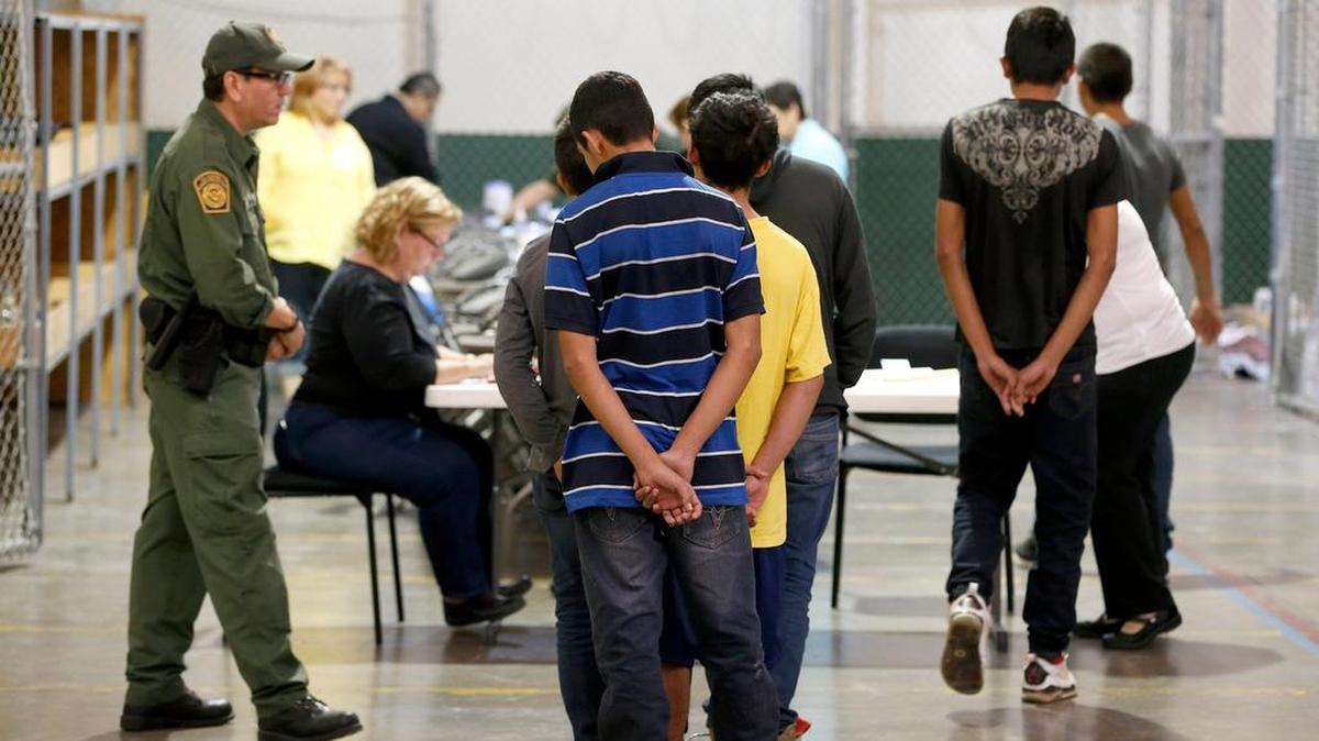 Un grupo de jóvenes menores de edad espera para hacer una llamada telefónica en un centro de detención de inmigrantes en Nogales, Arizona.