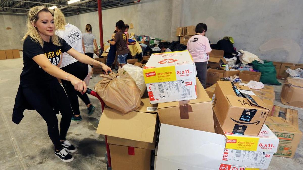 La voluntaria Andrea Otano mueve un carro lleno de cajas de alimentos y necesidades en el Comité de Alivio de Puerto Rico el viernes 6 de octubre de 2017 en Doral.