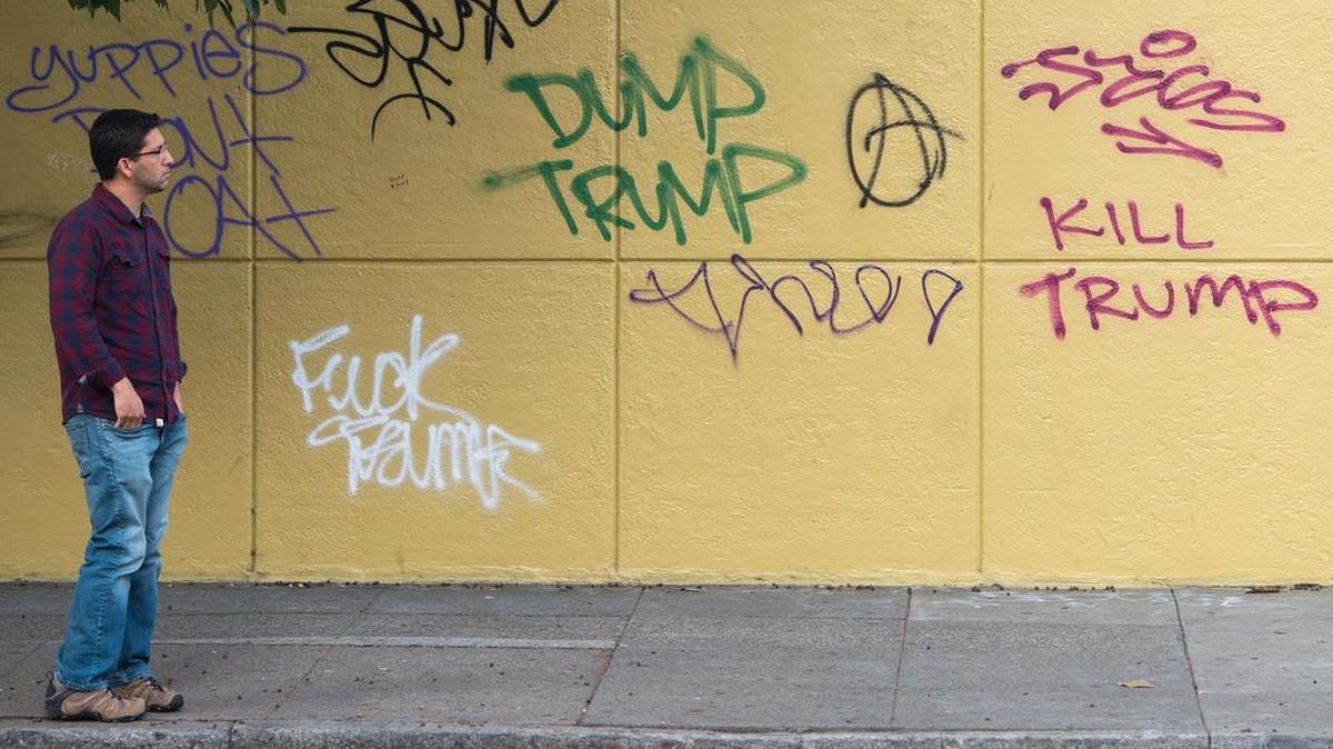 Un hombre mira un graffiti contra el presidente electo Donald Trump en el centro de Oakland, California, el 11 de noviembre de 2016.