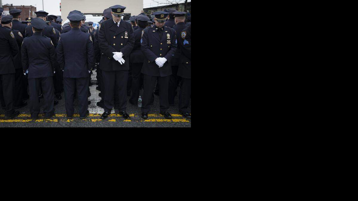 
Decenas de oficiales de policía muestran de espalda el domingo su inconformidad con las declaraciones del alcalde de Nueva York Bill de Blasio durante el funeral al agente asesinado Wenjian Liu.


