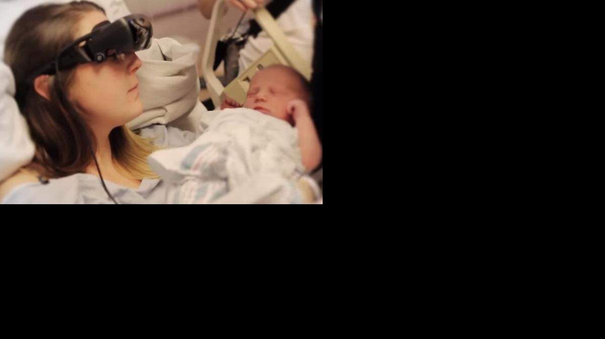 
El video subido a YouTube muestra a Kathy Beitz, de 29 años, mirando a su hijo recién nacido con la ayuda de unos lentes en un casco negro de gran tamaño.
