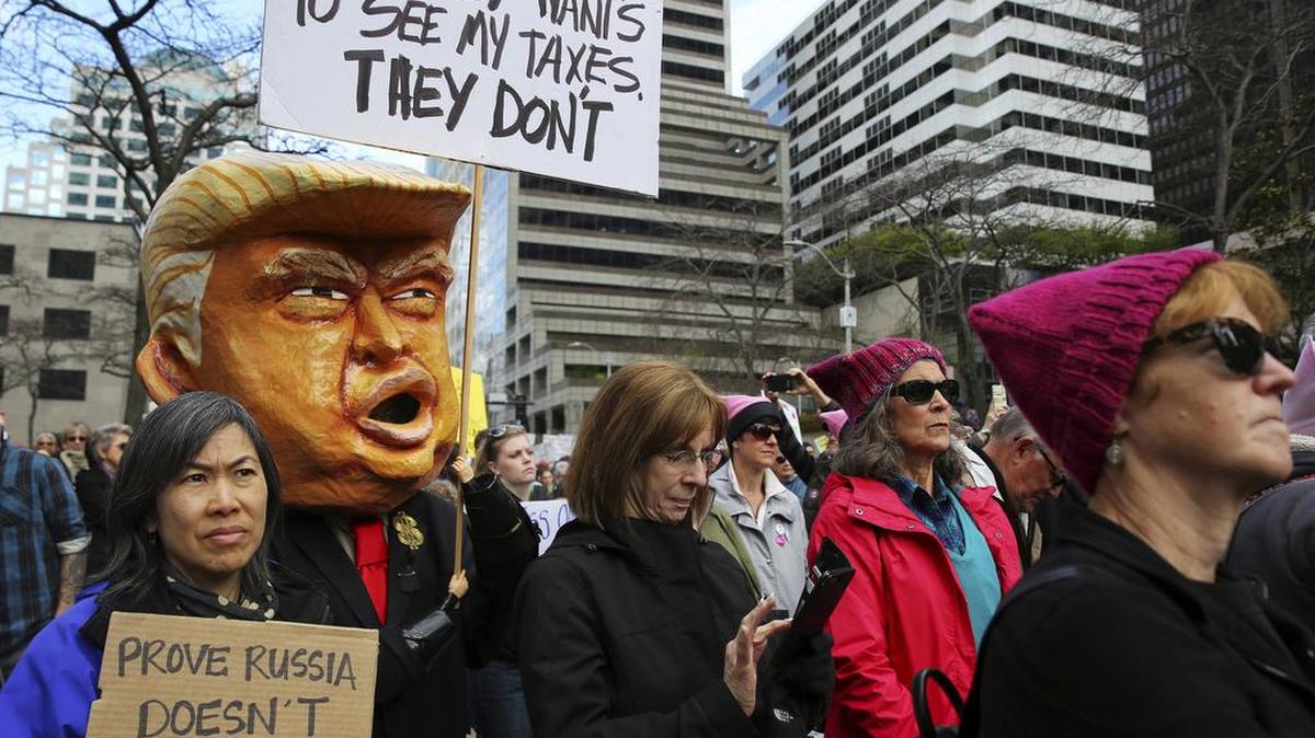 En esta foto del 15 de abril de 2017, manifestantes se desplazan por el centro de Seattle como parte de una convocatoria nacional para que el presidente Donald Trump publique sus declaraciones de impuestos.