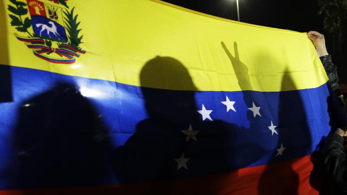 Manifestantes muestran una bandera venezolana. Foto de archivo.