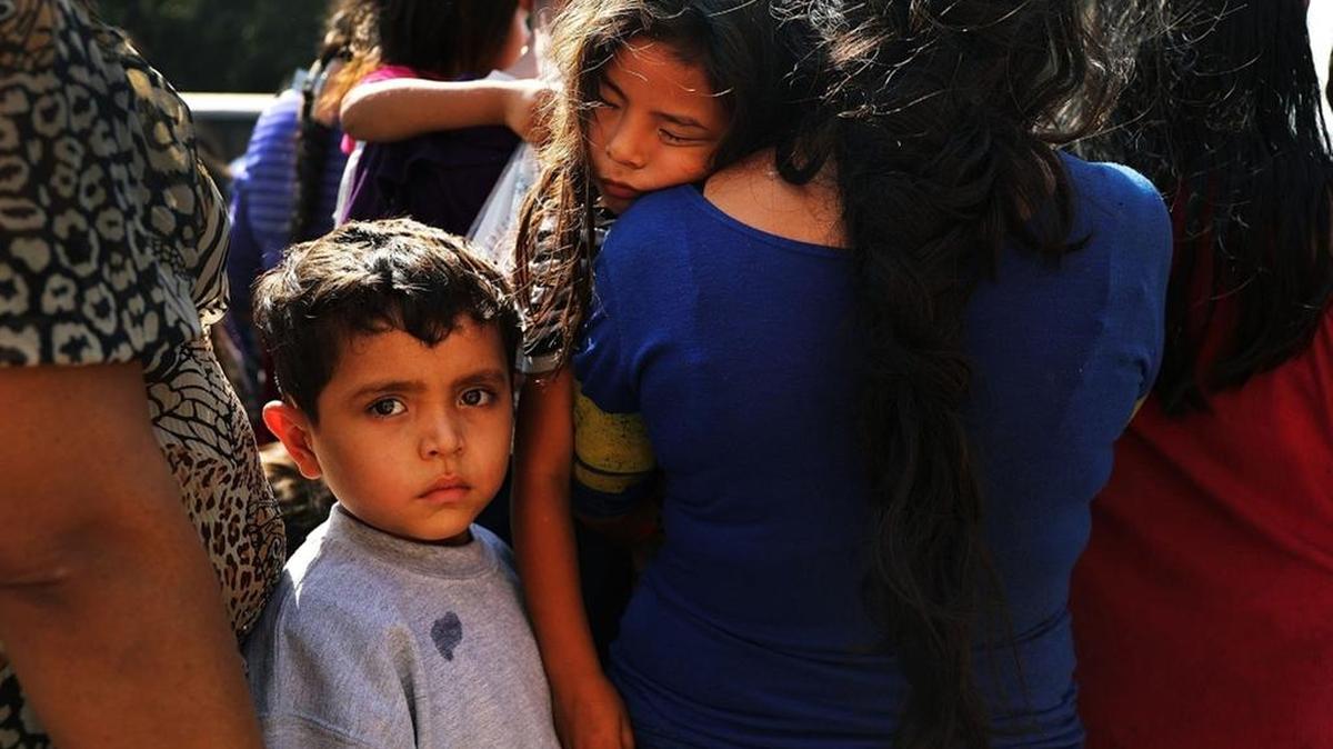 Decenas de mujeres y hombres con sus hijos, muchos huyendo de la pobreza y la violencia en Honduras, Guatemala y El Salvador, llegan a una estación de autobuses luego de ser dejados en libertad por agentes de Aduanas y Protección Fronteriza el 23 de junio de 2018 en McAllen, Texas.