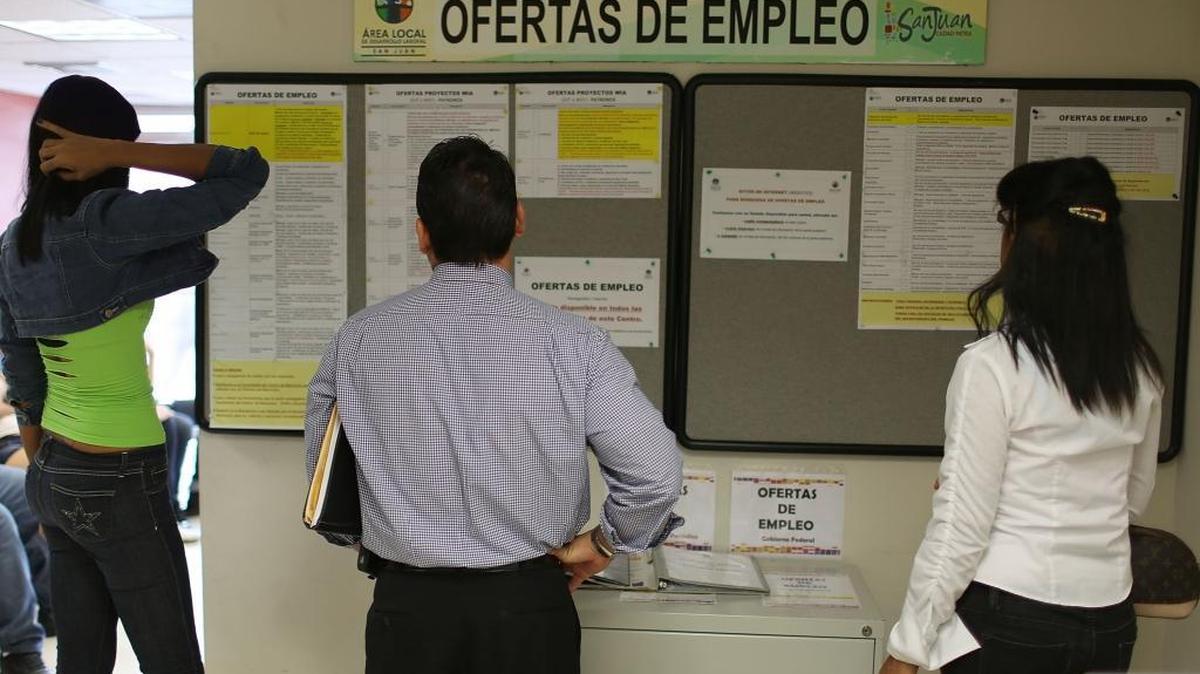Personas observan la lista de trabajos en una oficina de desempleo en San Juan, Puerto Rico, el 30 de junio.